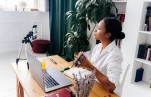 HOME Black woman using electronic devices for vlogging indoors at home office.